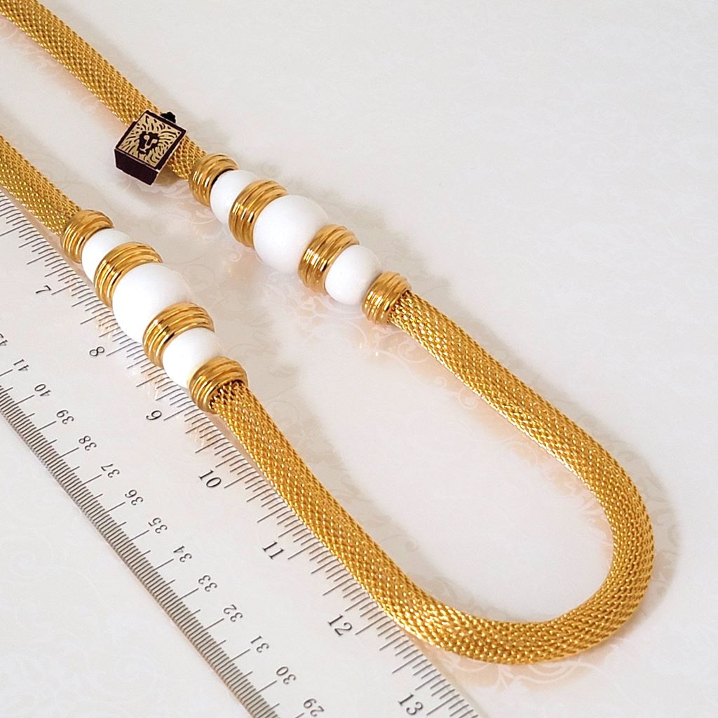 Closeup view of a vintage Anne Klein gold tone mesh tube style necklace. Shown next to a ruler.