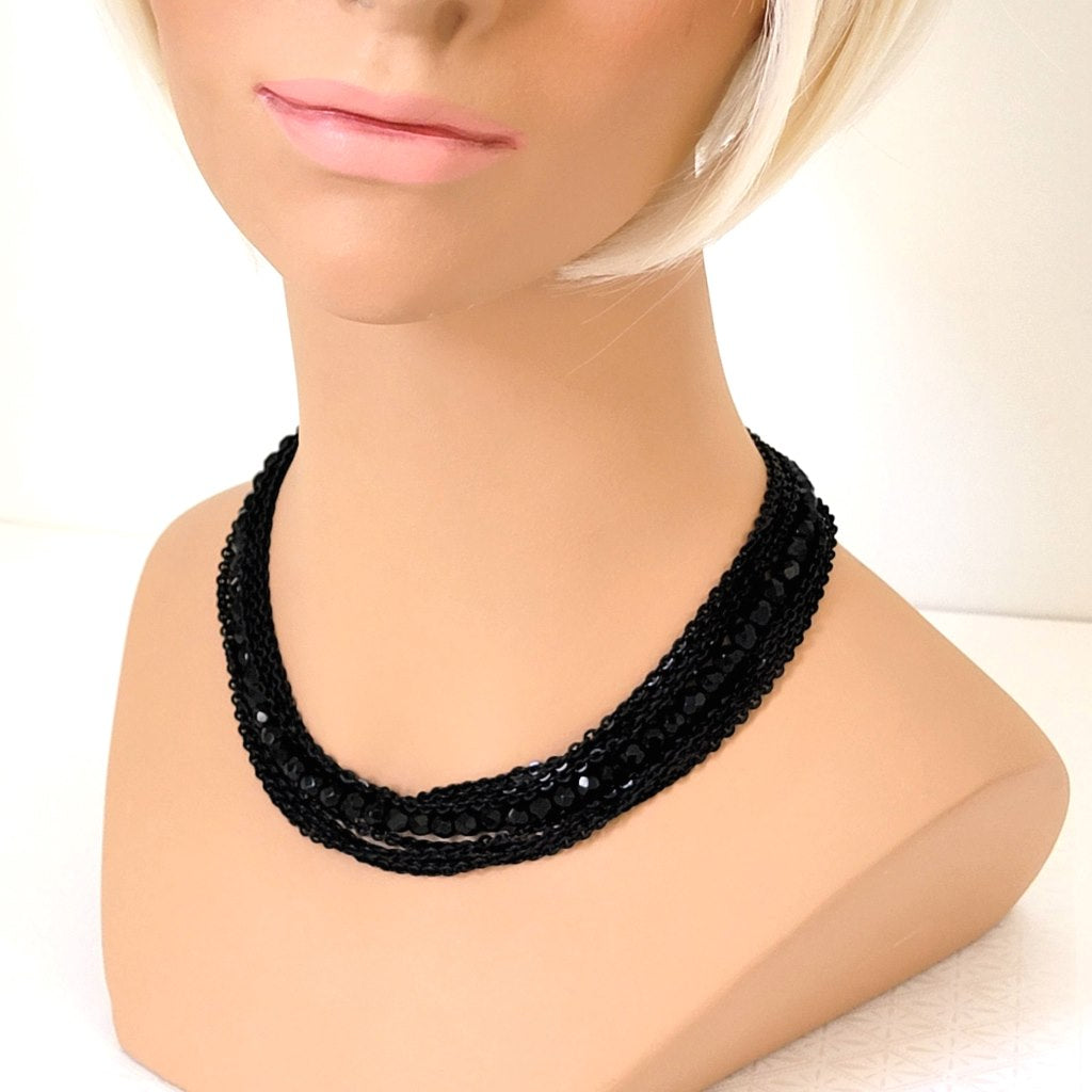 Vintage black multistrand necklace, with enameled chains and glass beads. Shown on a mannequin.