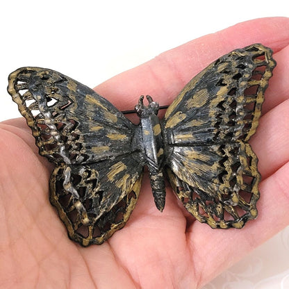 Vintage large Capri black and gold enamel butterfly brooch, shown in hand.