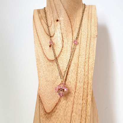 Long, vintage pink glass bead pendant necklace on display.