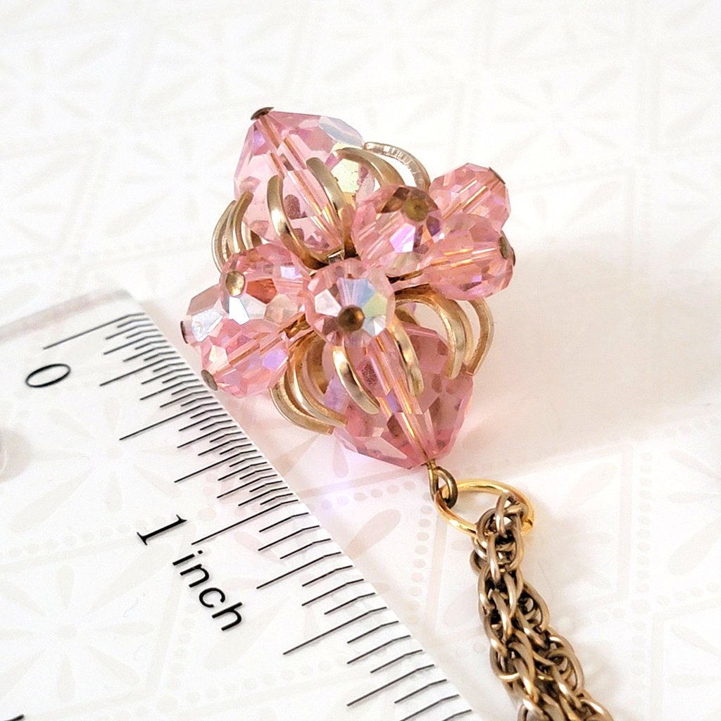 Vintage 60s pink glass bead pendant, next to a ruler.