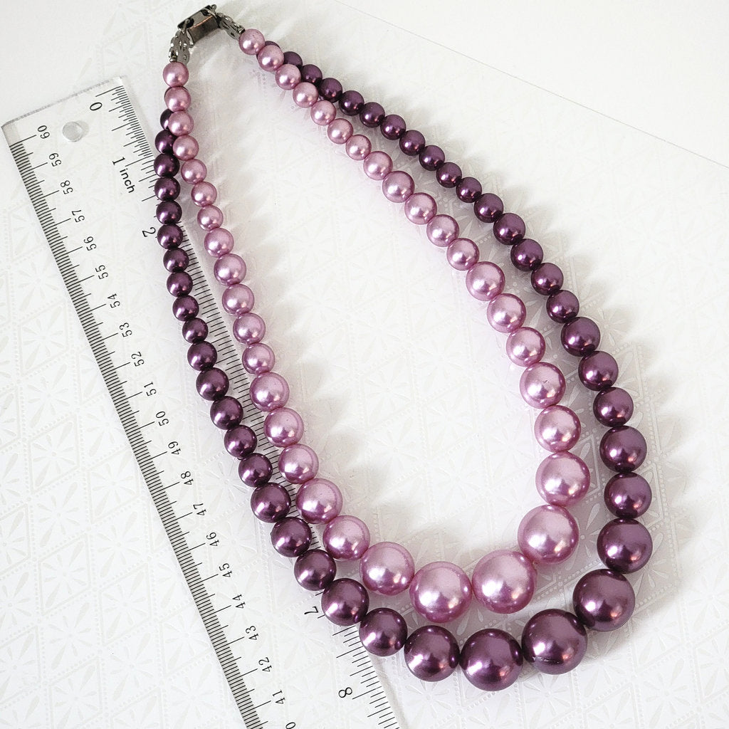 Vintage two tone purple faux pearl choker, next to a ruler.