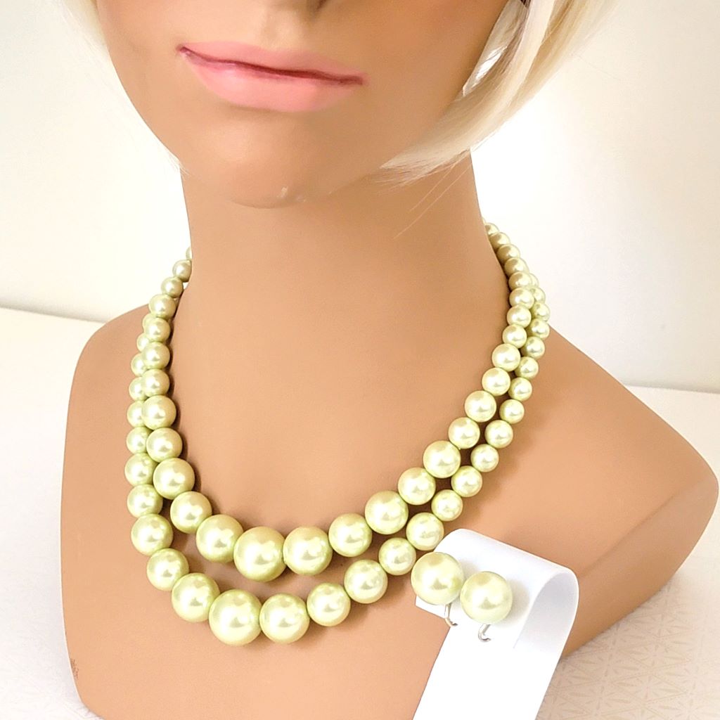 Vintage two strand light yellow faux pearl choker necklace and matching clip on earrings, shown on a mannequin.